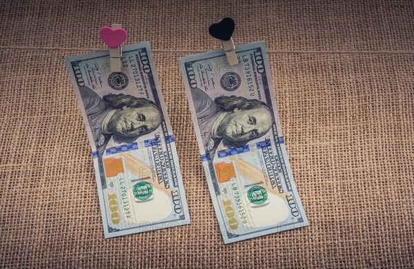 American 100 dollar banknotes with a heart clip on a string