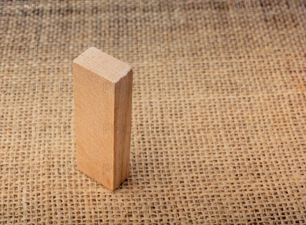 Wooden domino on a linen canvas background