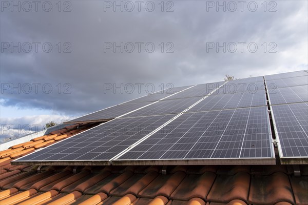 Close-up of photovoltaic system on red tiled roof