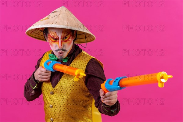Clown with white facial makeup on a pink background