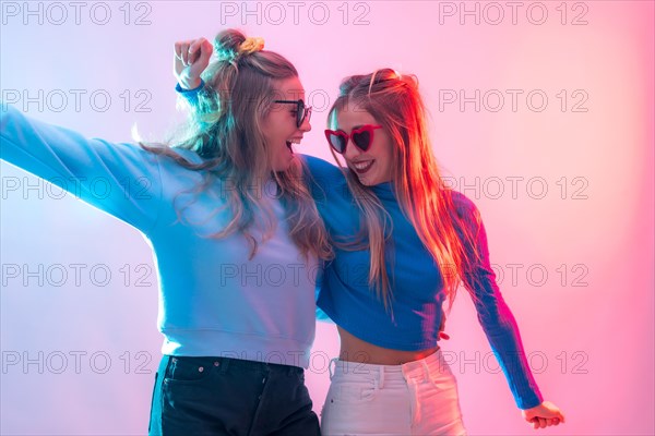 Two young blonde caucasian women dancing in disco