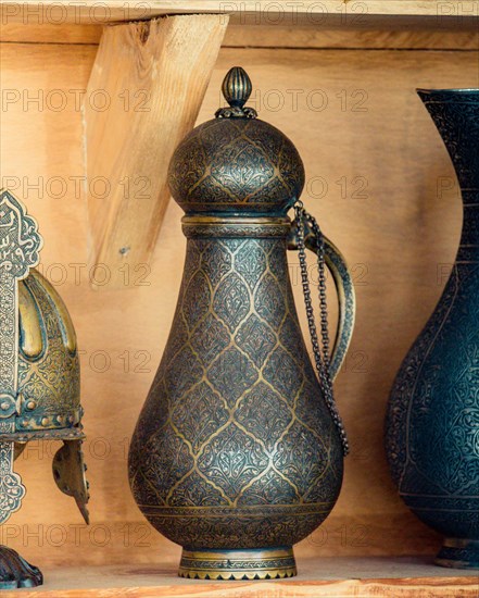 Ancient metal jug in oriental style in antique market