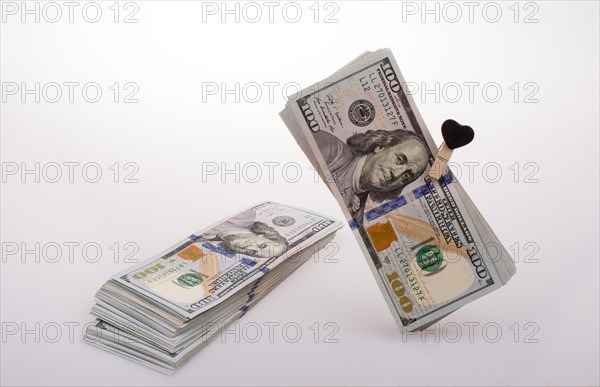 American 100 dollar banknotes with a heart clip on a string