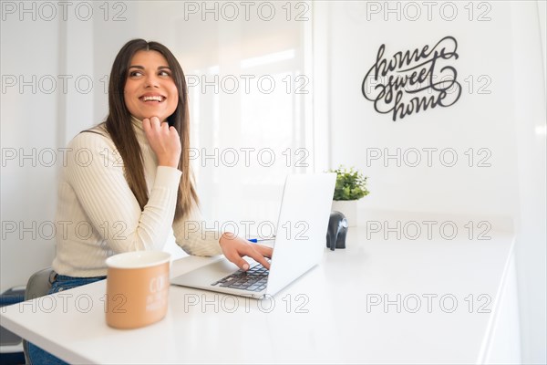 Business woman working on laptop sitting at home