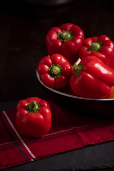 Red peppers in bowl on slate, fitness, cooking, vegetarian, vegan, vitamins, cultivation, healthy, close up, several, kitchen towel