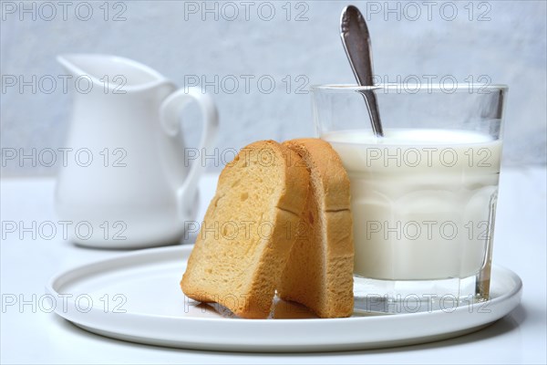 Rusk and glass of milk with spoon