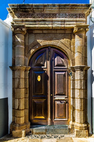 Old wooden doors with pebble mosaics on the floor, winding streets with white houses, Lindos, Rhodes, Greece, Europe