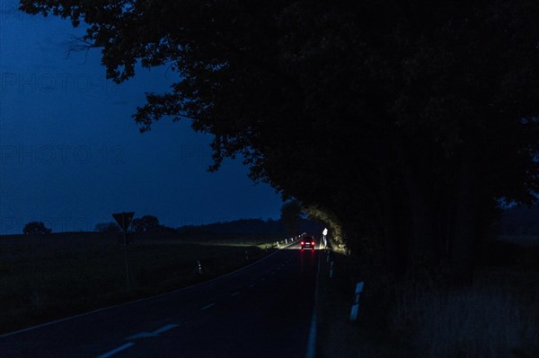 A car driving along a country road at blue hour in Reichenbach, Reichenbach, Germany, Europe
