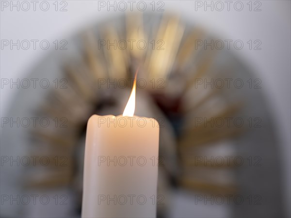 Burning candle in front of a Pieta in the Catholic parish church of St. Peter and Paul, former collegiate church, Romanesque columned basilica, Unesco World Heritage Site, Niederzell on the island of ...