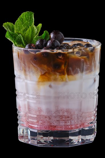 Summer refreshing black currant and cocoa milk cold cocktail isolated on black