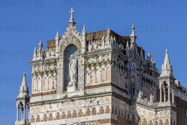 Detail of the top of the facade of the Capuchin Church of Our Lady of Lourdes with a statue of Our Lady of Lourdes decorated with a mosaic
