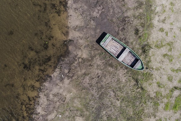 A boat lies on a dry bank at low water level
