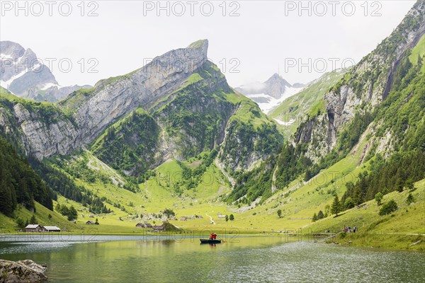 Two musicians blowing the alphorn in a boat