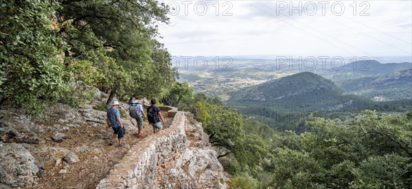 Hikers on the trail to the castle ruins of Castell Alaro