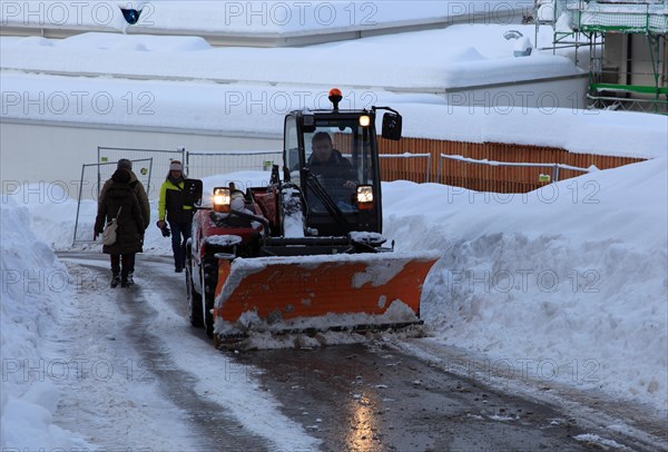 Winter service with snow plough on a country road in Upper Bavaria