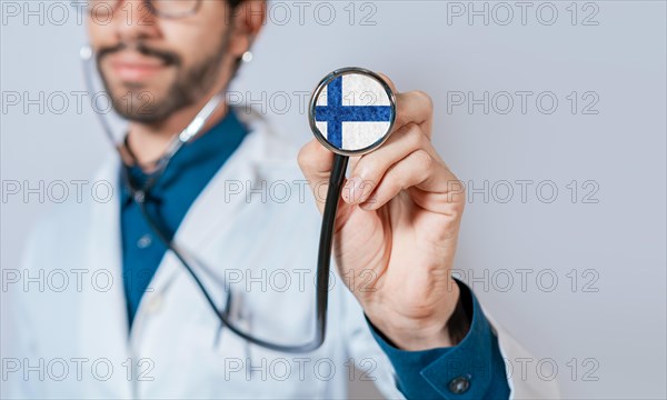 Doctor holding stethoscope with Finland flag. Finland Health and Care Concept