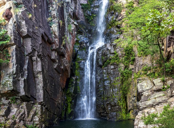 Beautiful waterfall of Veu da Noiva between the covered stones of moss and the vegetation located in an area of completely preserved nature in the state of Minas Gerais