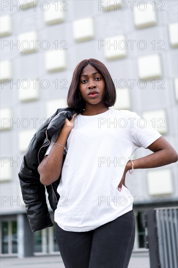 City fashionista: A young black woman poses in a fashionable white t-shirt and black pants