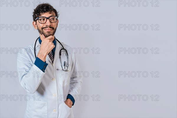 Pensive doctor man looking side isolated. Young doctor thinking and looking side isolated
