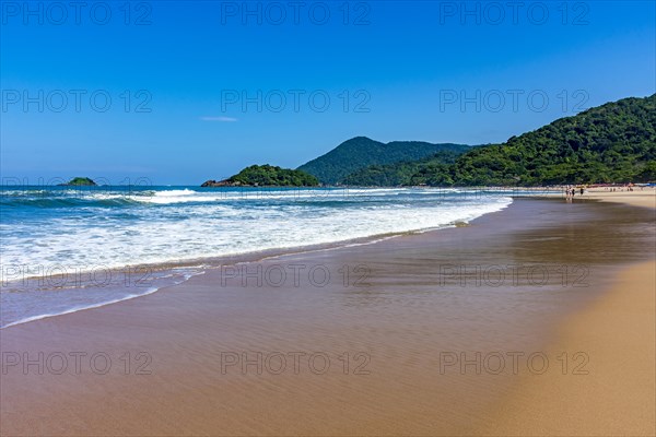 Paradise beach surrounded by rainforest and hills on a sunny day in Bertioga on the coast of Sao Paulo