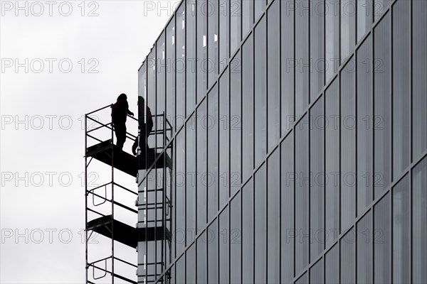 A construction worker is silhouetted on scaffolding in Berlin