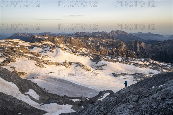 View of rocky plateau with snow and glacier at sunrise