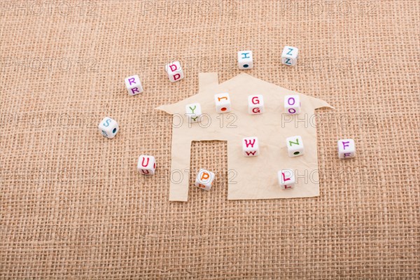 Letter cubes on house shape cut out of paper