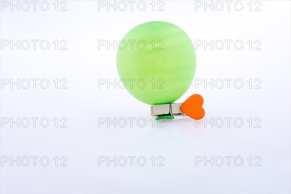 Clothespin with a heart and a balloon on white background