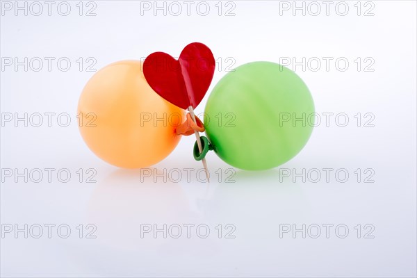 Red heart and colorful small balloons on a white background