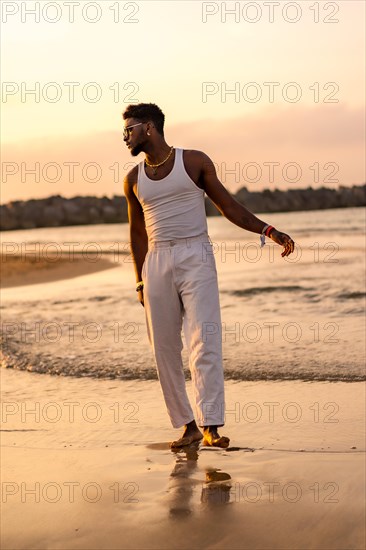 Portrait of black ethnic model enjoying summer vacation by the sea wearing a tank top