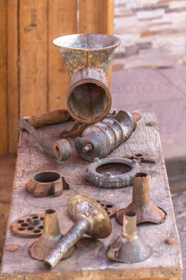 Antique sausage making machine with all its accessories on a wood table
