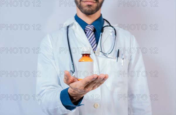 Doctor's hand holding a bottle of syrup. Doctor showing a bottle of syrup