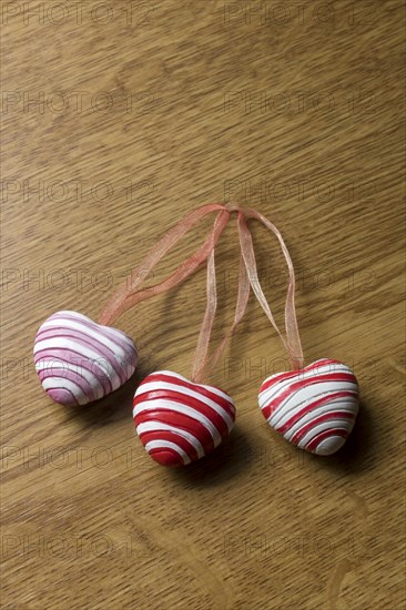 3 pendants in heart shape on wooden plate for decoration
