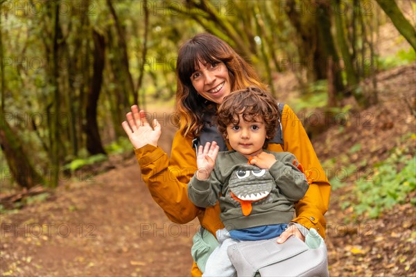 Mother and son having fun trekking on the trail in the mossy tree forest of Garajonay National Park