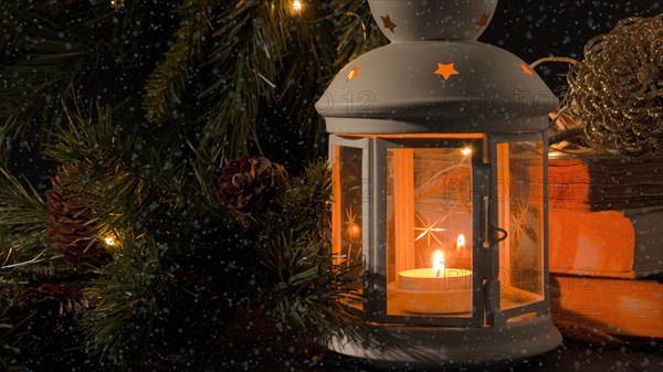 White lantern with a burning candle. Books
