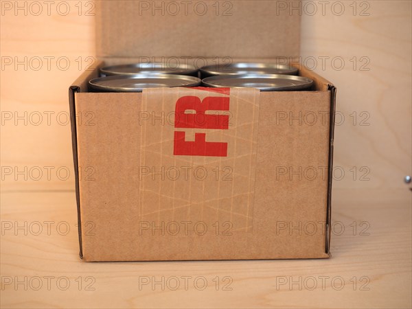 Fragile cardboard box with tin cans