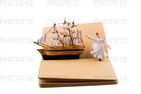 Sufi Dervish and a ship on a notebook on white background