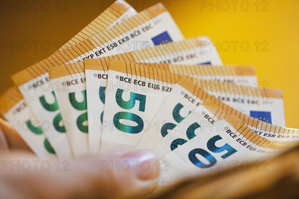 Symbolic photo on the subject of cash. 50 euro banknotes are held in one hand. Berlin