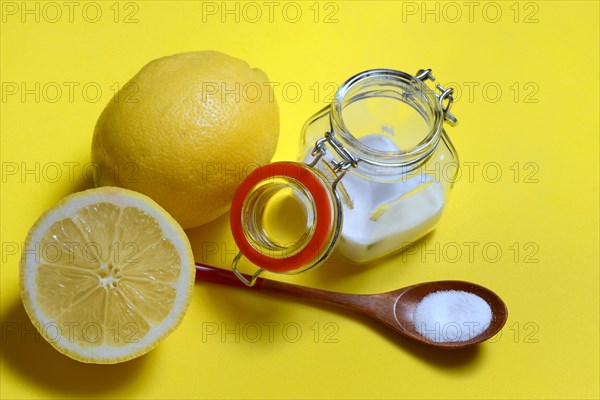 Citric acid in wooden spoon and glass container