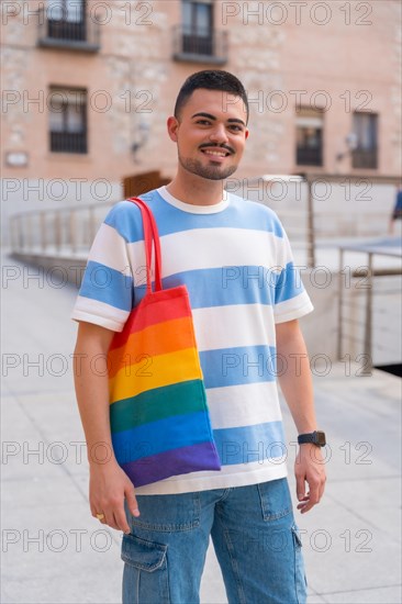 Portrait of gay man with a rainbow lgbt bag in the city