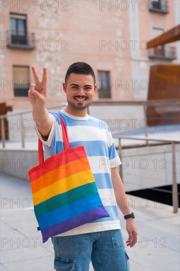 Portrait of gay man with a rainbow lgbt bag in the city