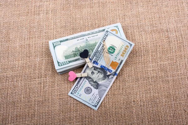 Heart icon bundle of US dollar placed on a linen canvas