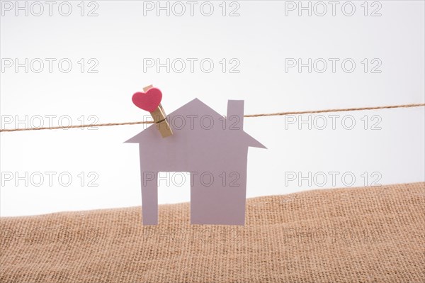 Little paper house attached to a string with a heart clip
