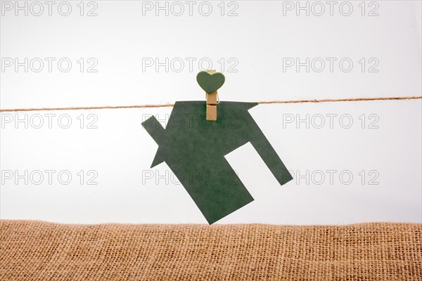 Little paper house attached to a string with a heart clip