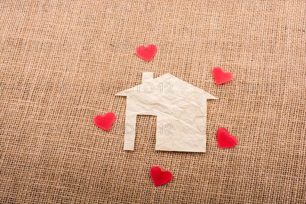Heart shape around the paper house with a canvas background