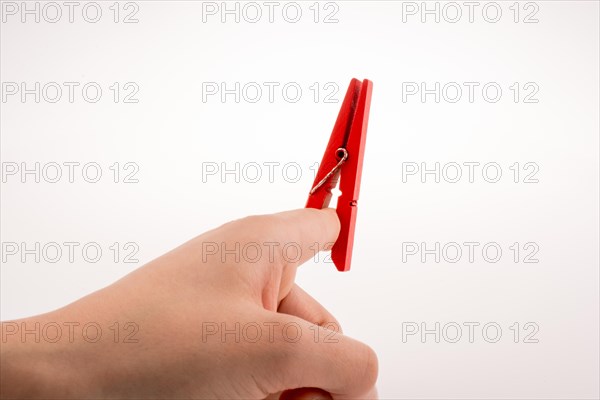 Hand holding a red clothespin on a white background