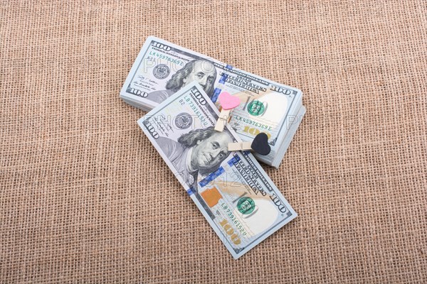 Heart icon bundle of US dollar placed on a linen canvas