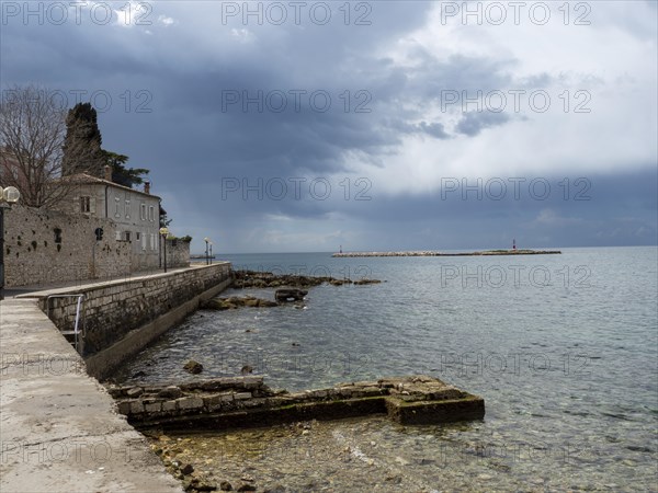 Coast with lighthouse in front of Porec