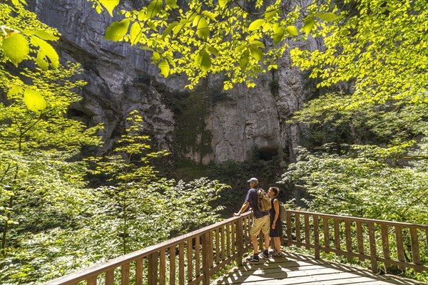 Tourists at the Creux Billard rock cauldron at the Source du Lison near Nans-sous-Sainte-Anne
