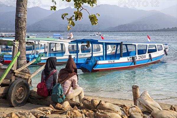 Two Indonesian women waiting for the ferry to the island Lombok at Gili Air